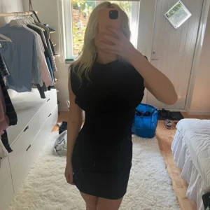 Svart ärmlös kortklänning från Zara - Säljer en svart, tight och ärmlös kortklänning från Zara. Klänningen har en enkel och stilren design med rund halsringning och markerade axlar. 