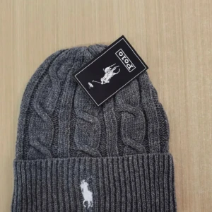 Grå kabelstickad mössa från Polo - Snygg grå stickad mössa från Polo med kabelstickat mönster. Helt ny! Ordinare pris runt 1300! Mitt pris 339