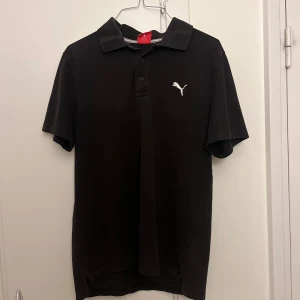 Svart Puma pikétröja i storlek M - Svart pikétröja från Puma i storlek M. Klassisk modell med krage, knappar framtill och vit Puma-logga på bröstet. Mycket bra skick. Pris kan diskuteras 🌸