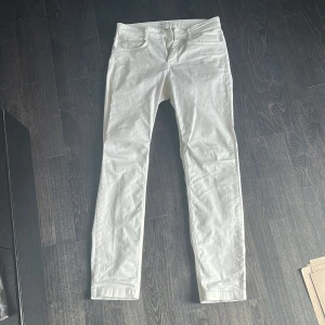 Vita jeans från These Glory Days - Snygga vita jeans från These Glory Days med klassisk femficksdesign och dragkedja. Byxorna har en rak passform och är tillverkade i bomullsmix som känns mjuk och följsam. Perfekta för dig som vill ha en clean och stilren look.