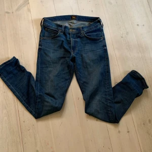Blå Lee jeans straight fit - Säljer ett par klassiska blå Lee Luke jeans i rak modell. Jeansen har fem fickor, snygga kontrastsömmar och Lee-logga på bakfickan. Modellen är slim och sitter snyggt längs benen. Perfekta för dig som gillar en tidlös denimlook. W29 L32. Pris kan diskuteras. Skriv om du har nå frågor! ☺️🙌