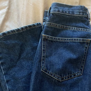 Mörkblå raka jeans - Säljer ett par mörkblå jeans som är midwaist och har raka ben. Jeansen är från Ginatrocot använda fåtal gånger så nästan som nya!