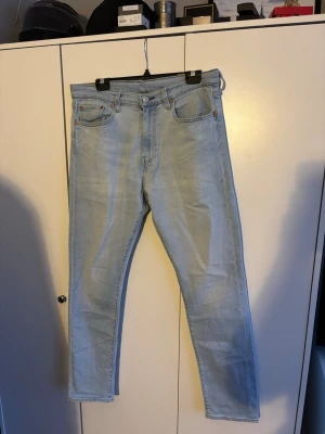 Levi's 512 ljusblå jeans W34 L32 - Säljer ett par Levi's 512 jeans i ljusblå. Klassisk modell med raka ben och normal passform. Jeansen har snygga detaljer som kopparfärgade nitar och Levi's patch bak i midjan. Perfekta till sneakers och hoodie. Säljer dom för de är för stora för mig. Inga tecken på användning. Pris kan diskuteras vid snabb affär👍