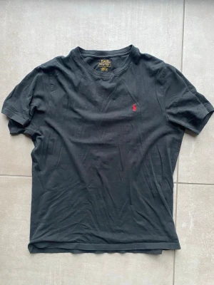 Svart t-shirt från Polo Ralph Lauren - Klassisk svart t-shirt från Polo Ralph Lauren med den ikoniska röda logon broderad på bröstet. 