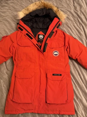 Canada goose expedition jacka - Canada Goose Expedition Parka - Herr. Storlek S, röd färg och tillverkad i dun. Mycket bra skick. Jag är första ägaren och den kommer från ett rök och djurfritt hem. Hör av dig vid frågor.