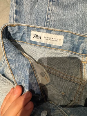 Ljusblå raka jeans från Zara - Säljer ett par ljusblå jeans från Zara i rak modell. Klassisk femficksdesign med bälteshällor och knappgylf. Jeansen har en snygg tvättad look och är tillverkade i bomull för en skön känsla. Perfekta till sneakers eller boots.