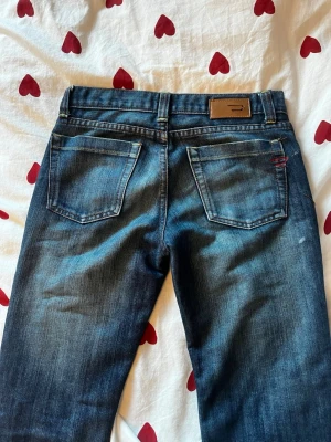 Low waist diesel jeans - Säljer ett par mörkblå jeans från diesel med låg midja och raka/bootcut ben. Jag har försökt lägga ner jeansen, därav ser du väldigt slitna ut längst ner(se andra bilden). Säljer då de är för korta i benen på mig. 