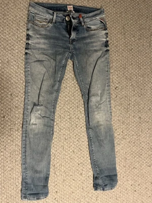 Replay ljusblå skinny jeans med nitar - Säljer ett par ljusblå slim jeans från Replay med snygga slitningar, storlek 28-30. Nypris runt 1000, pris 219kr