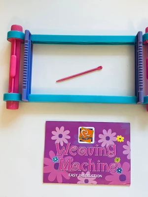 Pärlvävram - Weaving machine / Pärlvävram För att göra pärlarmband. Vävstol med nål och tvåsidig instruktion.  Kartong saknas, därav priset. För övrigt inget att anmärka på. Shun Xing