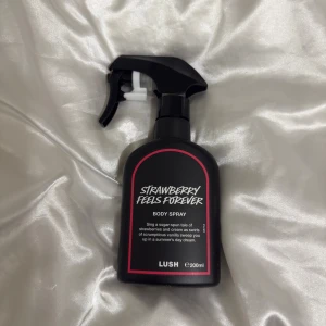 Strawberry Feels Forever Body Spray - Body spray från Lush med en söt och fräsch känsla. Innehåller bland annat glycerin, parfym, jordgubbsextrakt, vaniljextrakt och essentiella oljor. Vegansk och självkonserverande. Volym: 200 ml. Tillverkad i England.