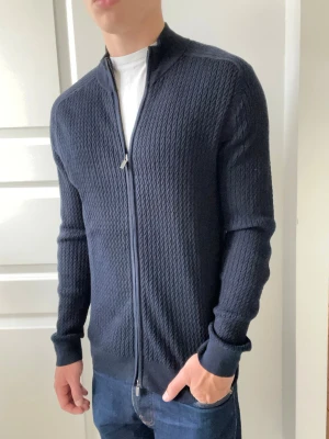 Massimo dutti full zip  - Massimo dutti full zip, en extremt clean Massimo full zip men unikt mönster och väldigt bra passform på modellen som är 180 cm 75 kg. Tröjan är väldigt slim fit men samtidigt stretchy pga av dess material / hur den är gjord. Inga defekter 