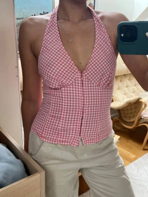 Rutig rosa korsett-topp med halterneck - Supersöt halterneck med knäppning framtill. Rosa gingham från H&M, uppskattad storlek är xs-s (lapp bortklippt). 
