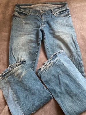 Blå bootcut jeans Lexington Co - Säljer ett par ljusblå bootcut jeans från Lexington Co. Jeansen har klassisk femficksdesign, slitna och fransiga benslut samt tydliga slitningar framtill. Tillverkade i jeansmaterial med normal passform och knappgylf. Perfekta för dig som gillar vintage vibe. Har gjort dem bootcut själv. 