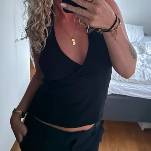 Svart halterneck  - En svart halterneck topp med öppen rygg. Stretchig och super skönt material! Knyte i nacken. 