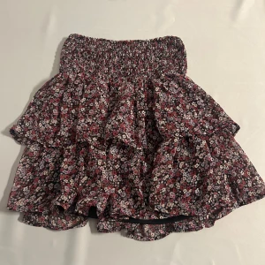 Gullig kjol - Säljer en väldigt fin volang kjol med blommor i olika rosa/lila färger. Den har ett mer tecknade lager tyg på insidan. Aldrig använd. I strl 146/152 från Kappahl men passar mig som har XS-M. Väldigt stretchig. Passar såååå fint till allt möjligt på sommaren men även om du skulle vilja använda som topp eller med strumpbyxor under till våren!💞💞💞
