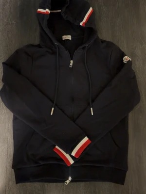 Moncler Zip Hoodie S - Säljer en riktigt snygg stilren Moncler Zip hoodie i färgen blå. Aldrig använd, helt ny har även vissa tags med. Storlek S