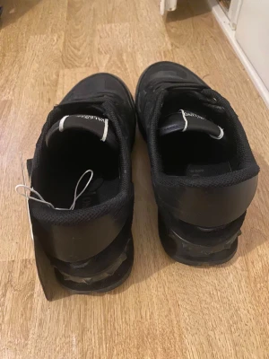 Valentino Garavani Rockrunners - Svarta Valentino Garavani Rockrunner sneakers med snyggt kamouflagemönster och platt sula. Skorna har snörning, rund tå och detaljer i både skinn och textil. Märkeslogga på plösen och coola nitar på hälen ger extra edge. Perfekt för dig som gillar exklusiv streetstyle.