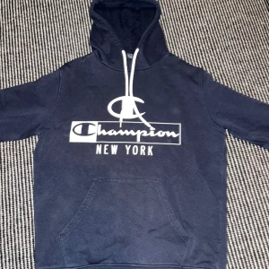 Blå Champion Hoodie - En bavy blue Champion hoodie i bra skick. Den har använts ett fåtal gånger.
