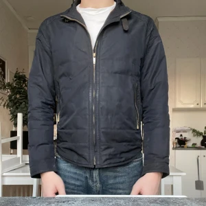 Jacka - Svart jacka från Massimo dutti med snygga guldfärgade dragkedjor och ståkrage med spänne. Jackan har två fickor + innerficka med dragkedja med dragkedja fram och diskreta detaljer baktill. Perfekt för dig som gillar stilren look. ( kameran fungerar ej baktill därför är bilderna så dålig kvalité) Stlk M