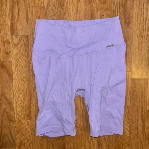 Ljuslila ribbade cykelshorts - Säljer ett par ljuslila cykelshorts från Aim’n med ribbad struktur och hög midja. Perfekta för träning eller chill dagar. Mjukt och stretchigt material som sitter skönt på kroppen.