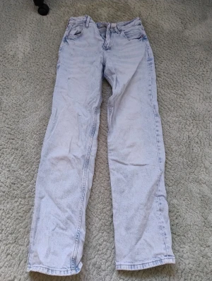 Ljusblå straight leg jeans från H&M - Säljer ett par ljusblå jeans från H&M med rak passform och justerbar midja. Klassisk femficksdesign och snygg tvättad look. Sparsamt använda.