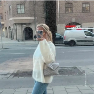 Oversized ljusbeige stickad tröja - Mysig oversized stickad vit tröja med rund hals och långa ärmar. Tröjan har en enkel och clean look, perfekt att slänga på sig över jeans.