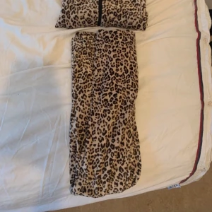 Leopardmönstrade mjukis sett i mjukt tyg - Säljer ett par snygga byxor med leopardmönster. De är i ett mjukt och skönt material, perfekta för dig som vill sticka ut lite extra. Byxorna har en avslappnad passform och resår i midjan för extra komfort. Samt en siptröja med med extremt skön material speciellt till vintern.
