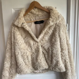 Beige teddyjacka från Vero Moda XS - Supermjuk och fluffig teddyjacka från Vero Moda i beige färg. Jackan har hög krage, hel dragkedja och är helfodrad för extra komfort. Perfekt för kyliga dagar när du vill ha en mysig och trendig look. Det är även fickor på jackan 