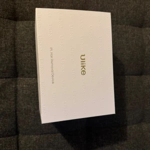 Ulike IPL Hair Removal Device - Ulike IPL Hair Removal Device i originalförpackning, komplett med skyddsglasögon och strömadapter. Enheten ser ut att vara i mycket gott skick utan synligt slitage. Perfekt för effektiv hårborttagning hemma med modern IPL-teknik. H