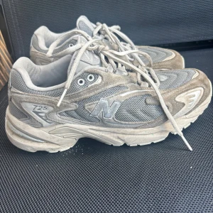 Grå New Balance 725 sneakers - Säljer sonens beige/grå New Balance sneakers i herrstorlek EU 41/US 8.  Hela, men inte helt rena. I helt okey/bra använt skick och skorna har mycket mer att ge!  Skickar inom 2dagar!  Skriv om du undrar något eller vill ha fler bilder😊  Mvh Mimmi
