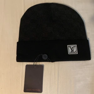 Svart mössa - Snygg svart mössa. Mössan har uppvikt kant och är tillverkad i ett mjukt, stickat material som känns lyxigt och stilrent. Perfekt accessoar för att lyfta din outfit med en exklusiv touch.