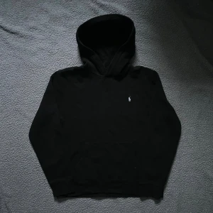Svart hoodie från Polo Ralph Lauren - Svart hoodie från Polo Ralph Lauren med klassisk vit broderad logga på bröstet👕 väldigt bra skick✅ skickar snabbt efter att du har beställt📦 XL i barnstorlek= ca S I herrstorlek