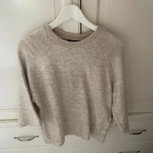 Beige stickad tröja från Gina Tricot - Mysig beige stickad tröja från Gina Tricot i storlek S. Tröjan har rund halsringning, långa ärmar och en avslappnad passform.