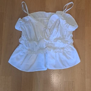 Vit volangtopp från H&M  - Supersöt vit topp från H&M i storlek XS med tunna axelband och volanger