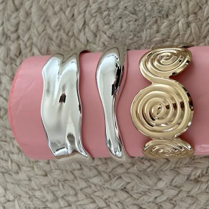 Tre chunky armband i guld och silver - Säljer fyra statement-armband i metall, två i blankt silver och ett i blankt guld. Två av armbanden har en vågig, organisk form och det tredje har en cool spiraldesign. Perfekta accessoarer för att lyfta din outfit med en modern touch. 1 för 59 kr 2 för 99kr eller alla för 179kr