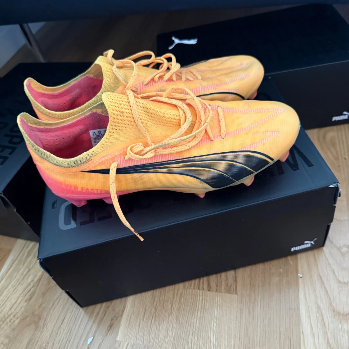 Puma orange fotbollsskor med svarta detaljer