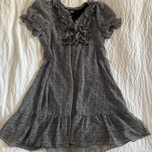 Svartvit prickig klänning - Svart klänning med vita prickar och fransar vid urringningen. Axelbredd: 37, Längd: 82