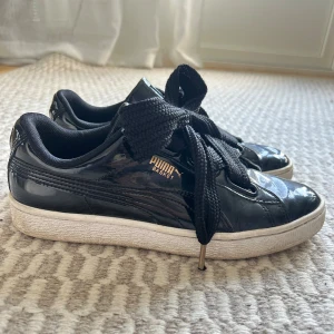 Svarta Puma Basket sneakers  - Snygga svarta Puma Basket sneakers i glansigt lack med breda svarta snören och vit sula. Använda men inga större skador, går att rengöra💓💓 