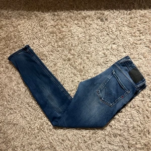 Blå Replay Anbass jeans slim fit - Replay anbass med slim passform. Mycket bra skick, inga märkvärdiga defekter eller liknande. Storlek w33 men sitter lite mindre, mått kan såklart skickas vid osäkerhet. Skön wash med snygga diskreta slitningar, 50kr rabatt ifall man kan mötas sthlm annars postas dem samma dag som köp eller dagen därpå🙌💯