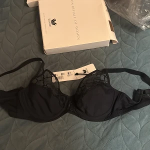 Svart spets-bh från Wacoal 80D - Snygg svart bh från Wacoal i storlek 80D står på lappen  men jag tror att den är 60 C. Kuporna har transparent mesh med coolt spetsmönster upptill och släta partier nedtill. Justerbara axelband och klassisk knäppning bak. Perfekt för dig som gillar stilrena detaljer och en feminin look.