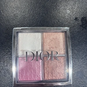 Dior highlighterpalett i fyra nyanser - Snygg highlighterpalett från Dior med fyra skimrande nyanser: isigt vit, champagneguld, rosabrun och ljusrosa. Kommer i en lyxig fyrkantig dosa med genomskinligt lock och Dior-logga. Perfekt för att skapa glow och highlighta ansiktet. Har endast använt den vita och guldiga några gånger.