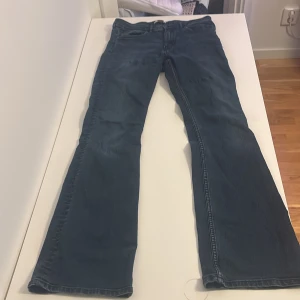 Blå bootcut jeans från H&M - Snygga blå jeans från H&M i klassisk bootcut-modell. Jeansen har normal passform och är tillverkade i ett mjukt denimtyg som sitter skönt. Perfekta för dig som gillar en tidlös look med lite utsvängda ben.