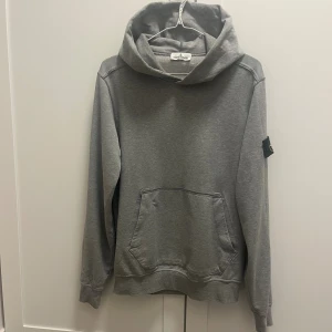 Stone Island hoodie - Säljer en Stone Island hoodie för jag ej vill ha den längre den är helt ny använts ett få gånger skicket är 10/10 och är fräsch som ni ser den är riktigt skön att ha nu inför hösten och vintern, den är  äkta vilket ni har bevis på den sista bilderna för att få en snabbaffär och svarar snabbt är det bara fråga mig om funderingar och bud. Storlek är 170 de motsvarar S men kan även passa M.