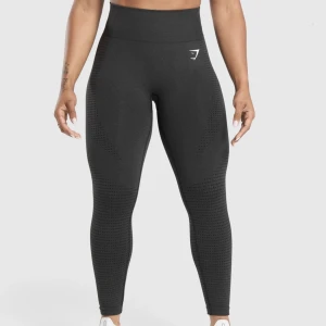 Svarta seamless leggings från Gymshark - Säljer ett par svarta seamless leggings från Gymshark med hög midja och diskret mönster längs benen. De är stretchiga och sitter tight, perfekta för träning eller chill. Materialet är mjukt och följsamt med Gymshark-logga på höften. I Ok skick enligt bilden. Nypris ca 500kr.