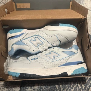 New Balance 550 sneakers blå/vit - Säljer ett par New Balance 550 sneakers i vitt och ljusblått storlek 43. Skorna är använda fåtal gånger och dom är som nya 