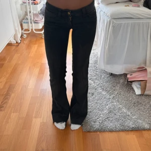 Svarta bootcut jeans från Cheap Monday - Snygga svarta jeans från Cheap Monday med bootcut passform och låg midja. storlek 26/32 men avklippta så passar mig som är 1,62. innerbenslängd: 78 cm midjemåttet rakt över: 35cm