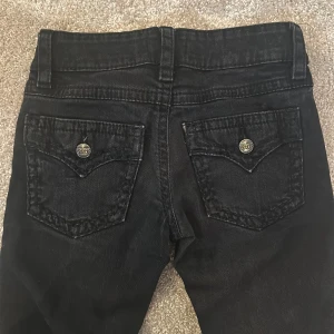 Svarta bootcut jeans från Gina Tricot - Svarta jeans från Gina Tricot med bootcut-modell. Snygga bakfickor med lock. Jeansen har en rak passform upptill och utsvängda ben. Lowaist