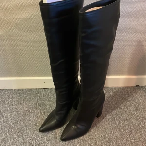 Svarta stövlar med klack - Snygga svarta stövlar i skinn med hög klack och spetsig tå. Perfekta för höst och vinter. 