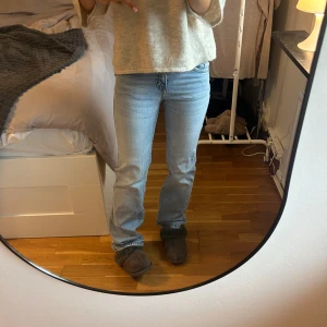 Ljusblå bootcut jeans med fickdetaljer - Snygga ljusblå jeans med bootcut-modell och klassiska fem fickor. Jeansen har dekorativa sömmar och detaljer på bakfickorna. Tillverkade i jeansmaterial med en skön passform och lätt utsvängda ben.