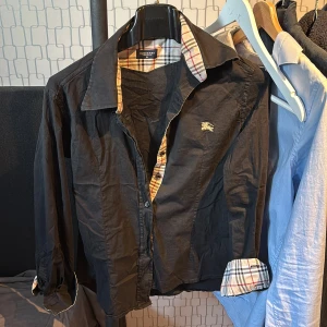 Svart Burberry skjorta med rutiga detaljer - Burberry skjorta tjej model står xl i men passar mer som S/xs 